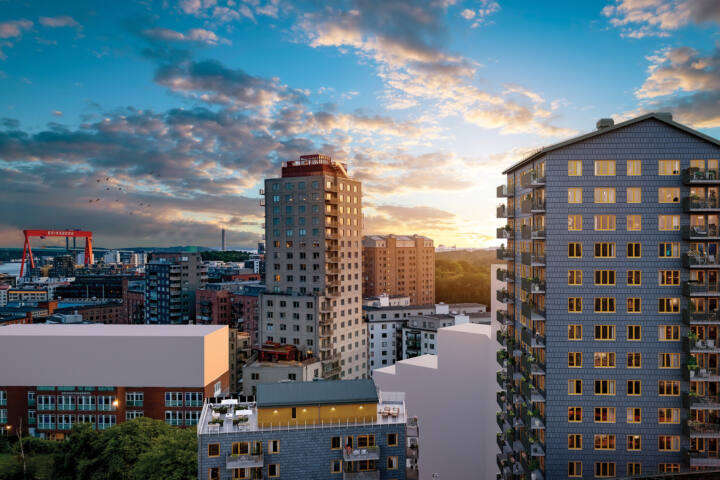 Solnedgångsbild i flygvy över på bostäderna högst upp i det grå höghuset Emerald i kommande Brf Eriksberget. Till vänster om höghuset syns även föreningens gemensamma takterrass på hus Granit.