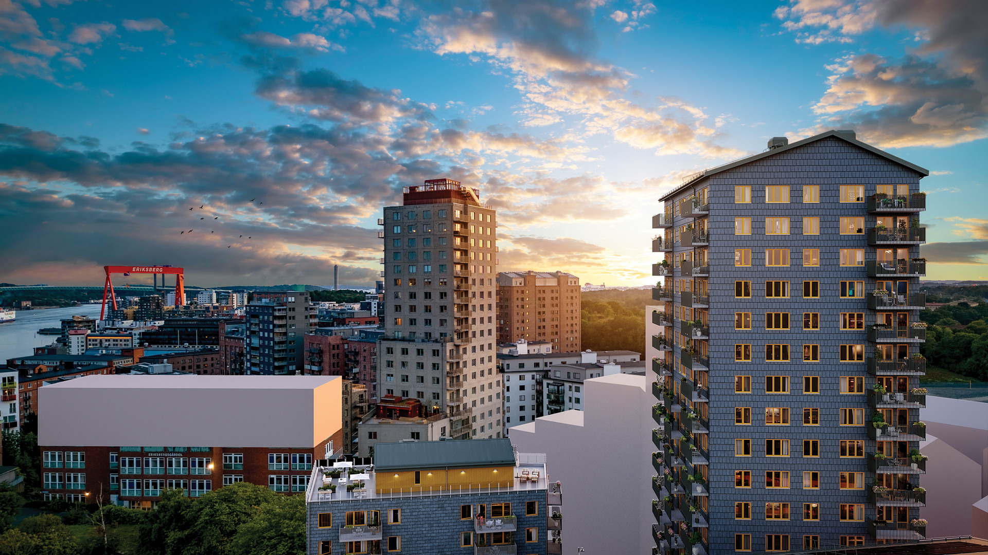 Solnedgångsbild i flygvy över på bostäderna högst upp i det grå höghuset Emerald i kommande Brf Eriksberget. Till vänster om höghuset syns även föreningens gemensamma takterrass på hus Granit.