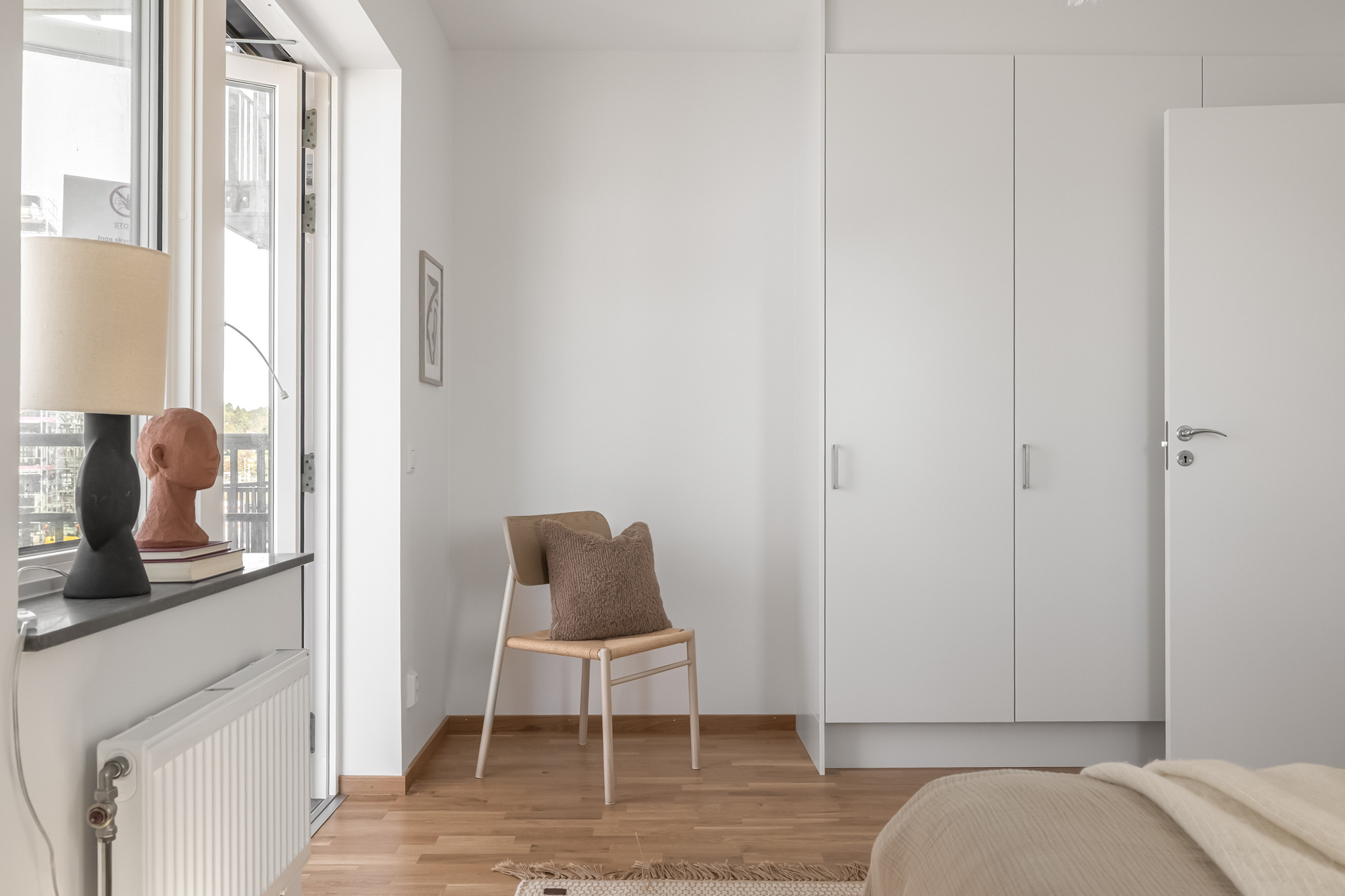 Ett rymligt sovrum i Brf Kvisljungeby Ängar, med stor dubbelsäng, garderober och generöst ljusinsläpp